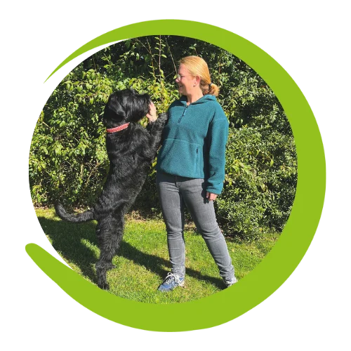 Beweglichkeit fördern Tierärztin steht mit großem Schnauzer im Garten